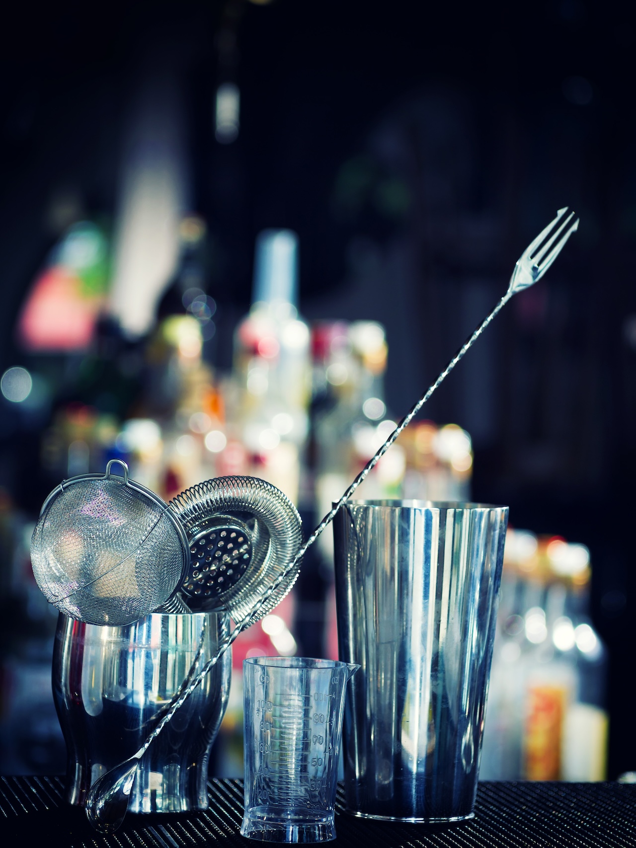 Bartender tools at the club over dark background - selective focus